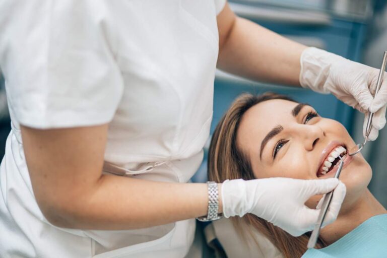 Patient wearing a nitrous oxide mask while a dental team monitors vital signs during treatment. KEYWORDS: ["dental sedation", "nitrous oxide dentistry", "dental anesthesia monitoring"]